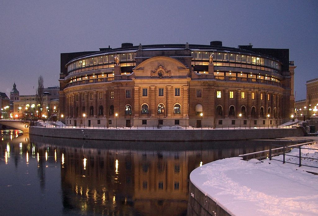 Vy från Riksdagshuset utifrån, i förgrunden syns vatten